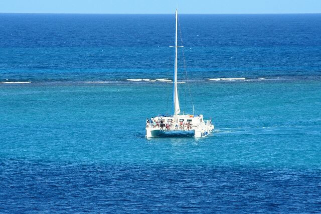 Catamaran sailing off into ocean