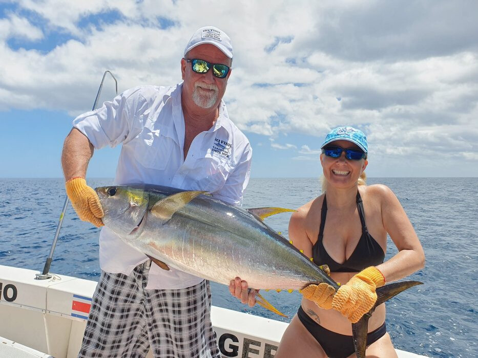 Couple holding fish together on boat