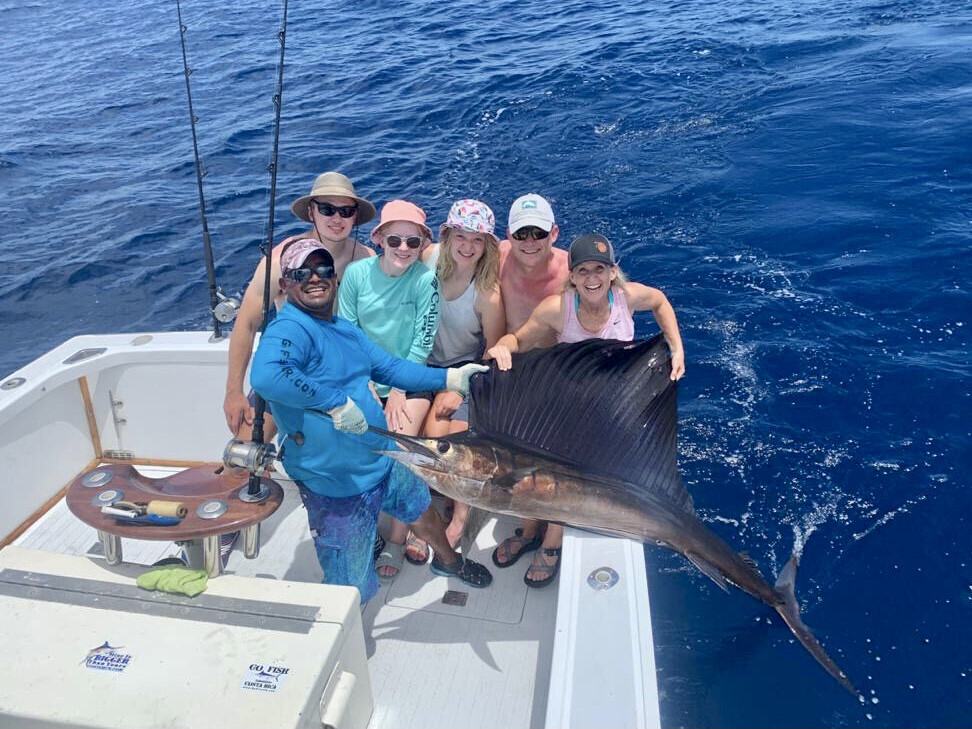 Family posing for camera with Marlin fish Costa Rica