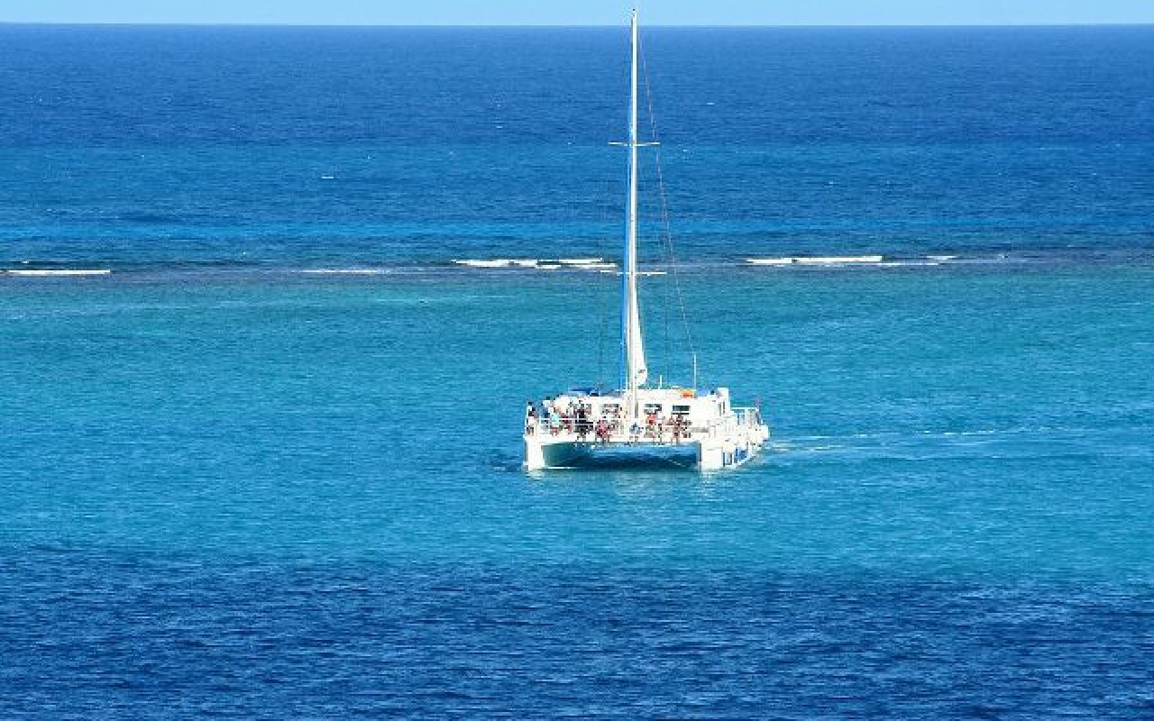 Catamaran sailing off into ocean