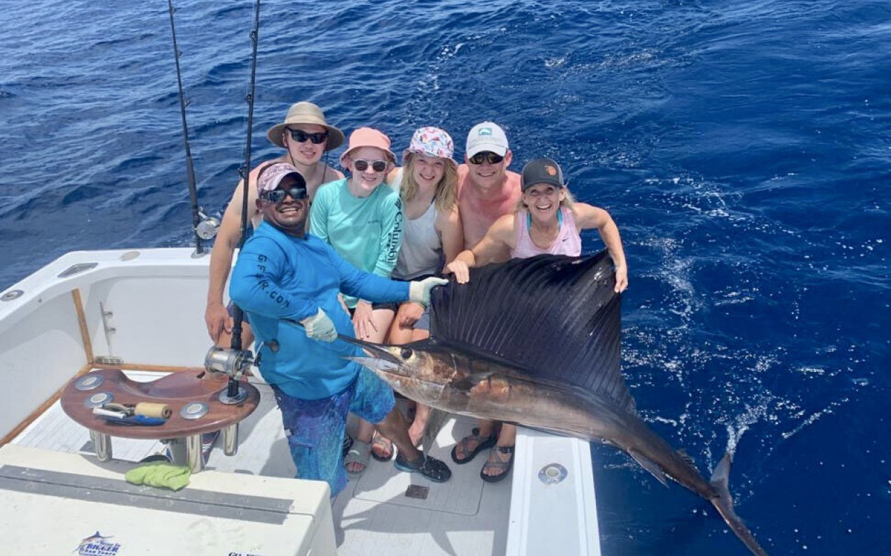 Family posing for camera with Marlin fish Costa Rica